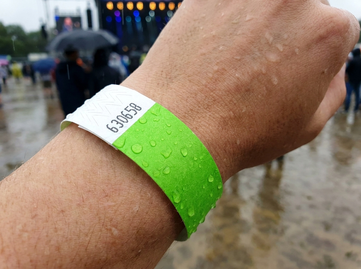 bracelet identification porté au poignet sous la pluie lors d'un festival en plein air, illustrant sa résistance à l'eau et à l'humidité