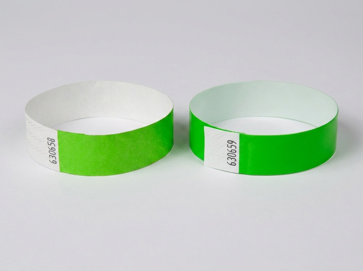 Comparaison côte à côte d'un bracelet Tyvek blanc avec code-barres imprimé et d'un bracelet identification coloré avec code-barres, posés sur une table de festival