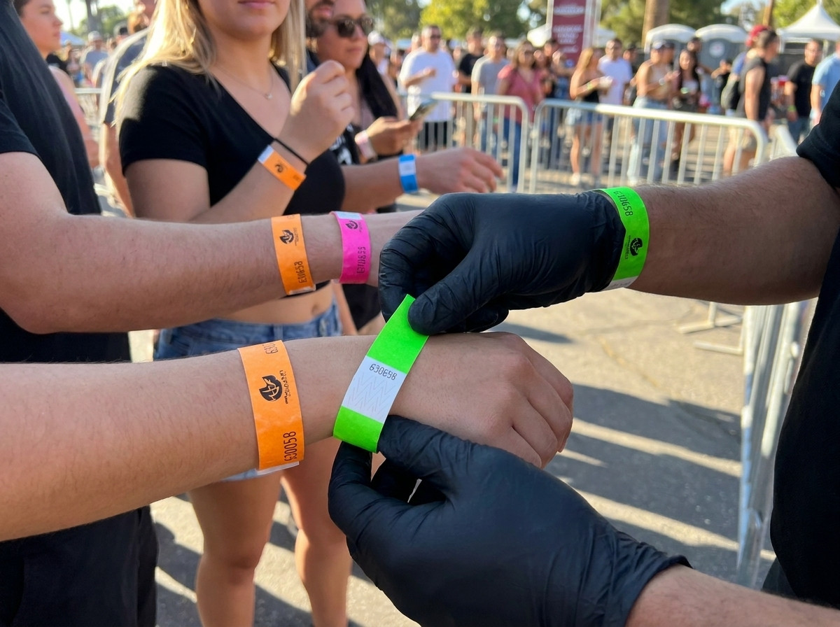Agent de sécurité vérifiant des bracelets colorés au point de contrôle des accès